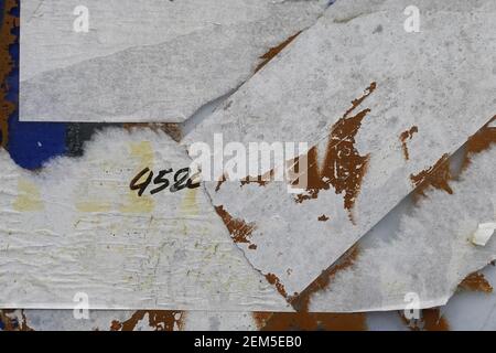 Torn paper stickers and chipped paint grunge background texture. Stock Photo