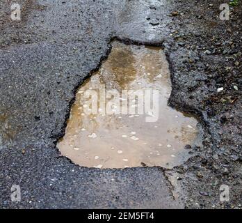 Pothole or pot hole damage in road surface Stock Photo