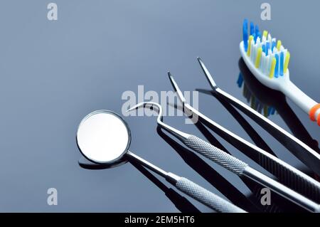 Dental care. Dental tools on a gray mirrored background. Dental treatment. Stock Photo