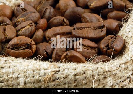 Roasted coffee beans in sacking bag. Selective focus. Stock Photo