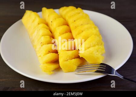 Slices of mouthwatering fresh ripe pineapple in white plate Stock Photo