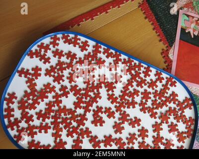 Jigsaws have become increasingly popular during Covid-19 lockdown; perseverence will be required to finish this puzzle where all the pieces are red. Stock Photo