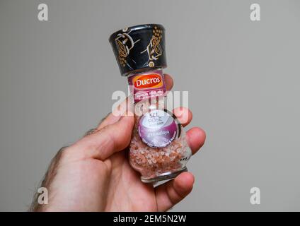 Paris, France - Nov 16, 2018: POV male hand holding looking at the new freshly unpacked the new Ducros rose Himalaya salt Stock Photo