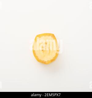 One banana slice, unpeeled. Isolated on white background with clipping path. Studio shoot. Stock Photo
