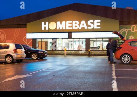 Customer loading their red car in the car park outside Homebase DIY store Stock Photo