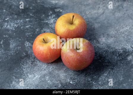 Three fresh red apples on a marble background Stock Photo
