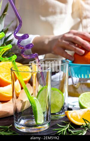 Girl cooking summer orange cocktail with mint and ice cubes outdoors ...