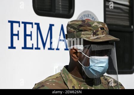 New York, USA. 24th Feb, 2021. A member of the Army National Guard assists people to register for COVID-19 vaccine shot appointments at a State-FEMA mass vaccination site at York College, in the Queens borough of New York City, NY, February 24, 2021. The MTA also announced that it is launching enhanced bus service fro NYCHA and community centers to York College for better public transportation to the sites starting March 1. (Photo by Anthony Behar/Sipa USA) Credit: Sipa USA/Alamy Live News Stock Photo