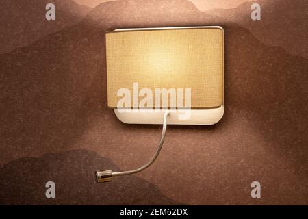 Fashionable beige spotlight on a textured wall, close-up, minimalism style. Concept interior details in neutral colors, light options in the house. Stock Photo