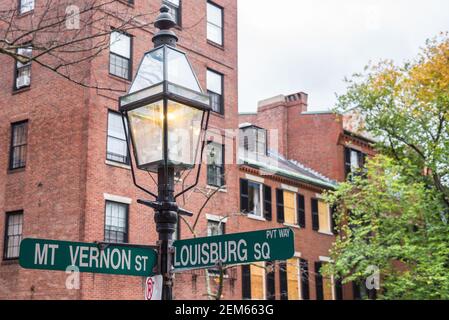 Close up of a traditional gas lit lamp post with street signs in the historic district of Beacon Hill in central Boston Stock Photo