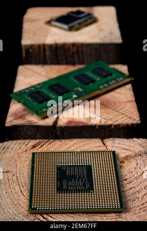 Processor and RAM memory from a personal computer stacked on raw wood. Accessories and spare parts for computer repair. Dark background. Stock Photo