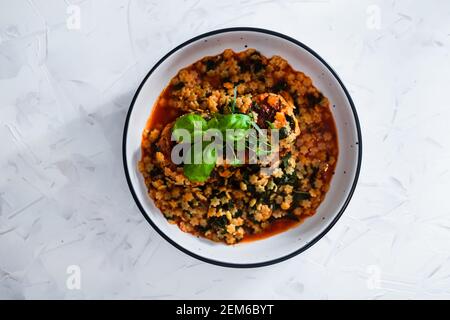 vegan meatballs with tomato sauce and tiny pasta topped with basil and herbs, healthy plant-based food recipes Stock Photo