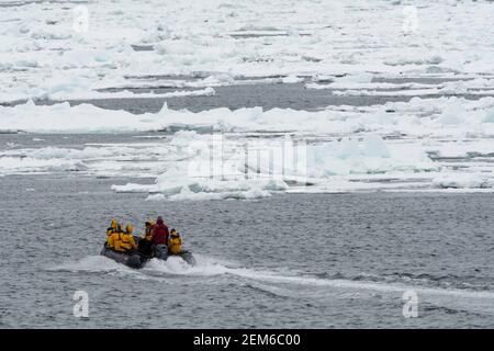 Tourists on zodiacs exploring  the polar ice cap, at 81* north of Spitsbergen. Stock Photo