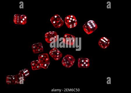 Many red dice flying on black background. Gambling concept. Stock Photo