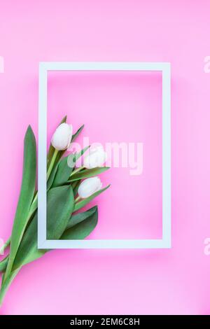 White tulips with picture frame on pink background. Holiday, Women's Day or Mother's Day concept. Top view, flat lay. Stock Photo