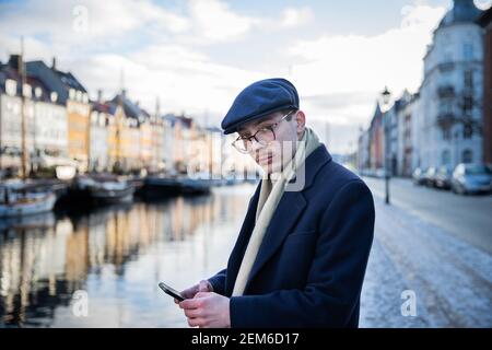 Elegant dressed businessman checks his phone while he is away from home. Stock Photo