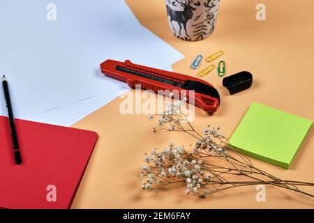 Office supplies, white paper, notebook, pencil and clips on orange background Stock Photo