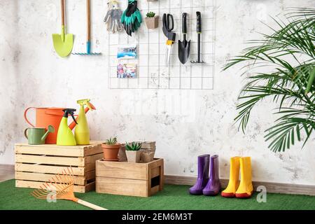 Set of gardening supplies and houseplants in barn Stock Photo