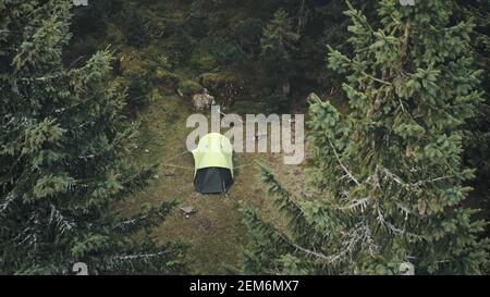 Closeup tent at pine trees forest aerial. Autumn nobody nature landscape. Pavilion at spruce mountain wood. Vacation at Carpathian mount, Ukraine, Europe. Mountaineering lifestyle. Travel and tourism Stock Photo