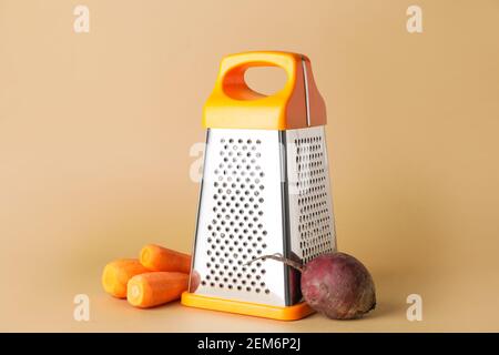 Metal grater, carrots and beetroot on color background Stock Photo