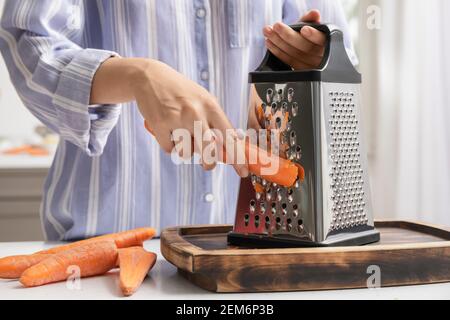 chef shredding carrots with grater in kitchen Stock Photo - Alamy