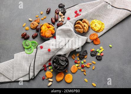 Bowls with different dried fruits and nuts on dark background Stock Photo