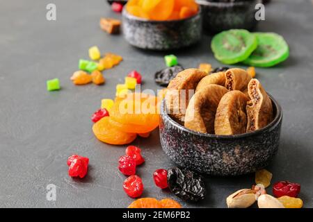 Bowls with dried figs on dark background Stock Photo