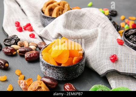 Bowls with different dried fruits and nuts on dark background Stock Photo