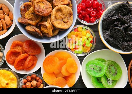 Bowls with different dried fruits and nuts on dark background Stock Photo