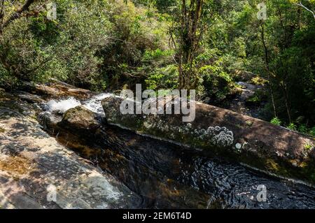 Fresh crystal clear water current from Ipiranguinha waterfall around over rock formations. This is one of the Serra do Mar tourist attractions. Stock Photo