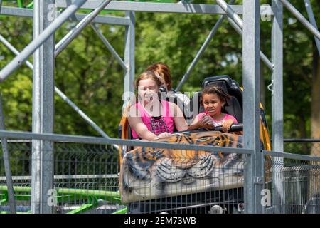 St. Paul, Minnesota.  13, 11 and 5 year old bi-racial sibling having fun on an amusement park ride. Stock Photo
