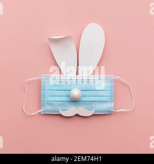 Coronavirus Easter bunny face made from rabbit ears and a protective face mask Stock Photo