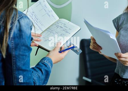 Two young coworkers enjoying working together, reading their ideas Stock Photo