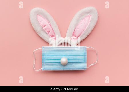 Coronavirus Easter bunny face made from rabbit ears and a protective face mask Stock Photo