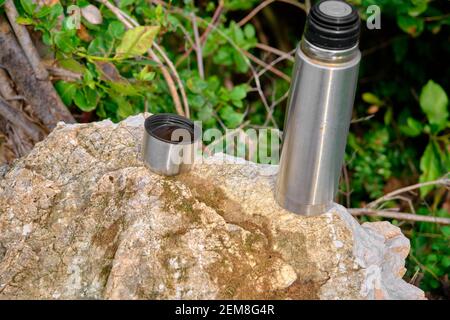 Caffe mug and heat sealing thermos cover made of stainless steel on thee  rock by taking photo during trekking in wild nature in forest Stock Photo -  Alamy