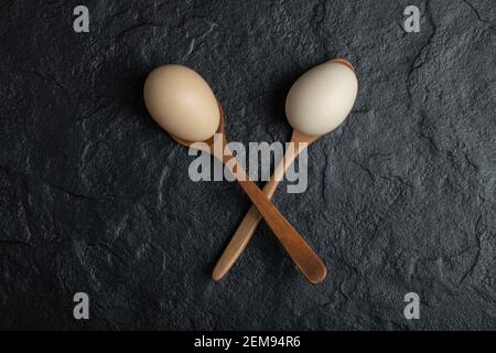 Spoons of chicken eggs on dark background Stock Photo