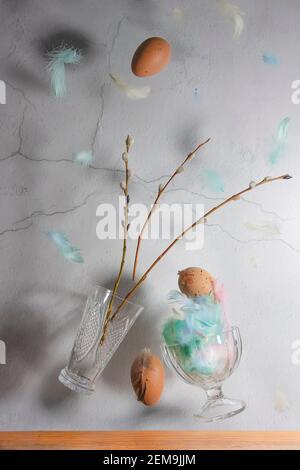 Willow twigs, vase, chicken eggs on a gray wall background. Levitation effect. Concept, easter. High quality photo Stock Photo