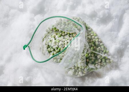 Top view on frozen green peas covered with tiny ice crystals in a net bag. Stock Photo