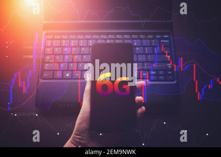 Female hands using smart phone with Virtual hologram 6G and finance digital line, smart phone and notebook computer. Mock up. Working from home, 6G ne Stock Photo
