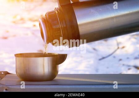 Thermos With A Steaming Mug Of Hot Drink Stands In The Snow Winter