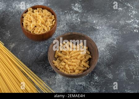 Three types of uncooked pasta on a marble background Stock Photo