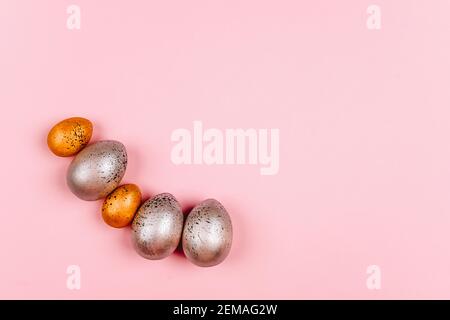 Silver and gold Easter eggs in a speck on a pink background Stock Photo
