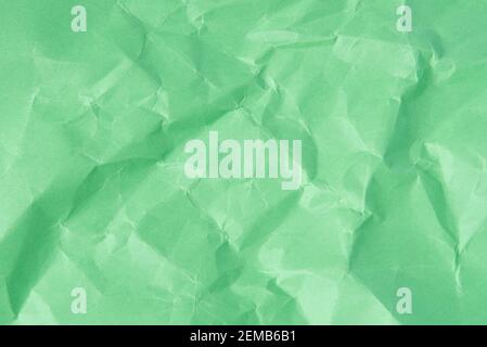 Crumpled sheet of green paper as a textural background for design ideas Stock Photo