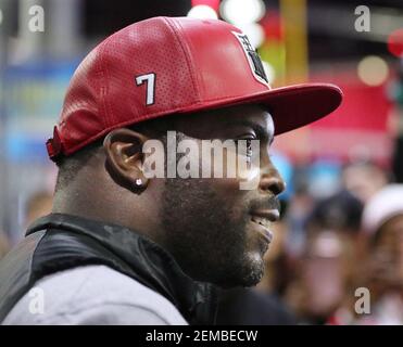 Former Atlanta Falcons and Philadelphia Eagles quarterback Michael Vick  wears one of his special edition New Era hats on sale in the NFL Shop at  the Super Bowl Experience on Thursday, Jan.