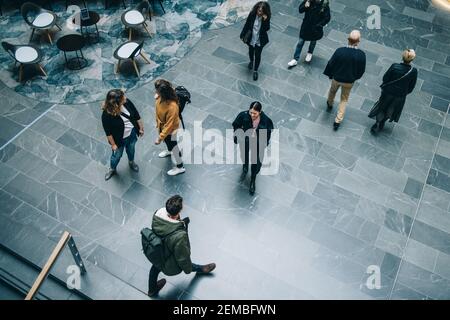 Crowd of people in modern office building hallway. business people walking across office lobby. Stock Photo