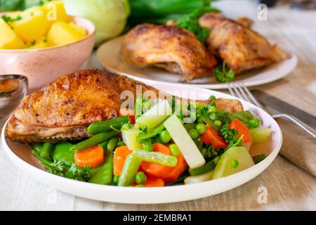 fresh cooked spring vegetables on a plate with chicken Stock Photo