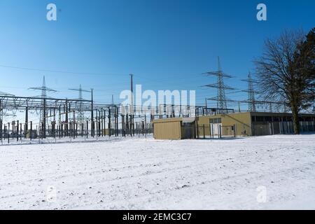 Electricity pole made of natural material in a winter landscape with a clear blue sky Stock Photo