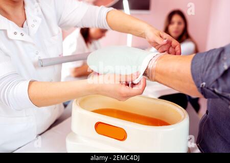Paraffin wax manicure treatment for soft and smooth skin, manicure salon Stock Photo