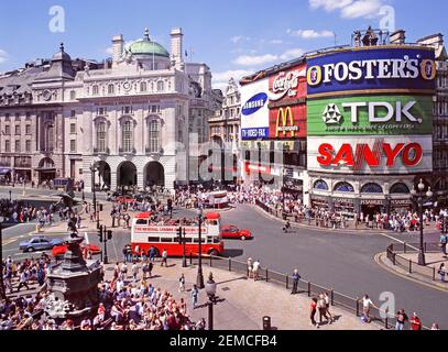 Iconic London West End 1995 tourism aerial archive image looking down on crowds of tourists around Eros statue and famous electronic illuminated brand advertising panels with travel people sightseeing from open top double decker tour bus in Piccadilly Circus road junction a busy street scene & archives of the way we were in England UK in the 1990s Stock Photo