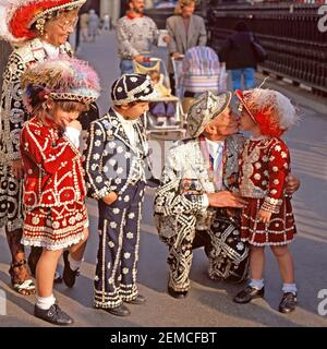 Historical 1988 archive image group of Pearly Kings and Queens an organised charitable tradition of working class culture in London with families meeting up outside St Martin in the Fields for annual Harvest Day thanksgiving festival and church service with young children boy ang girls wearing similar pearlies costumes all decorated with mother of pearl buttons a1980s archival image of the way we were in England  United Kingdom 80s Stock Photo